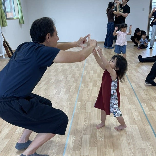親子英会話.ヒルトップインターナショナルスクールのBaby Englishクラスで、「Twinkle, Twinkle, Little Star」に合わせて一緒に踊るお父さんと娘さん。A father and daughter dancing together to “Twinkle, Twinkle, Little Star” during Hilltop International School’s Baby English class.