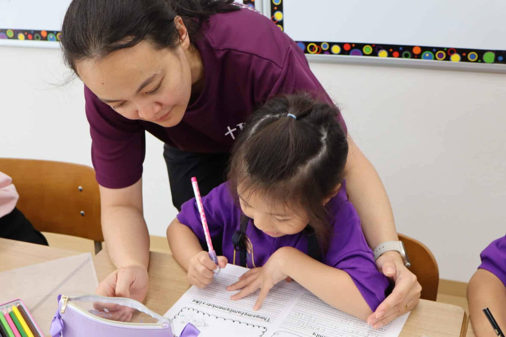 A highly skilled native English speaker teacher instructing a first grade girl student.