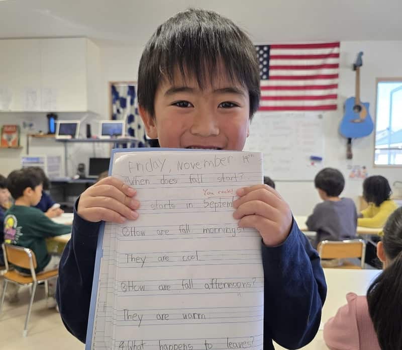 熊本のヒルトップインターナショナルスクールで英語のノートを見せる5歳の男の子