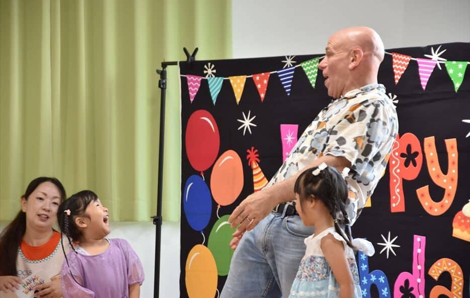 The school principal and one student having fun at a birthday party.