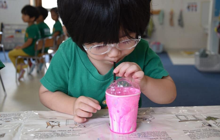 A child experimenting with paint bubbles.