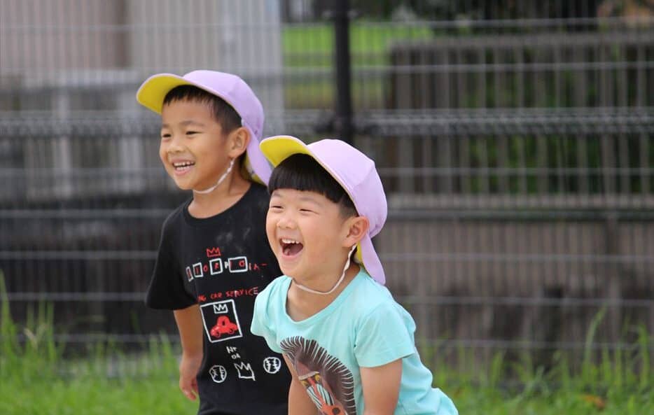 Two boys playing soccer at recess.