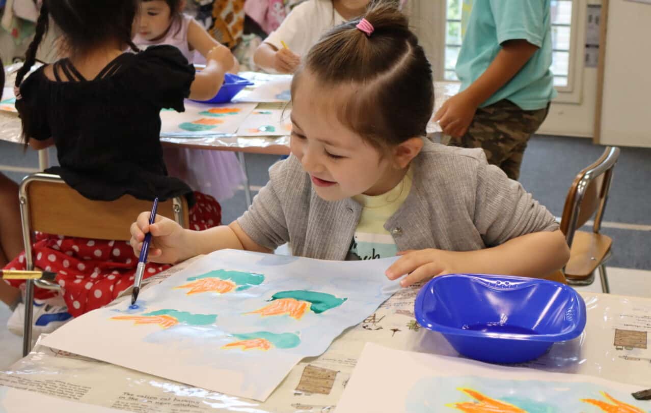 熊本のヒルトップインターナショナルスクールで、睡蓮の絵を描く子供。A child painting water lilies during an art at Hilltop International School in Kumamoto.