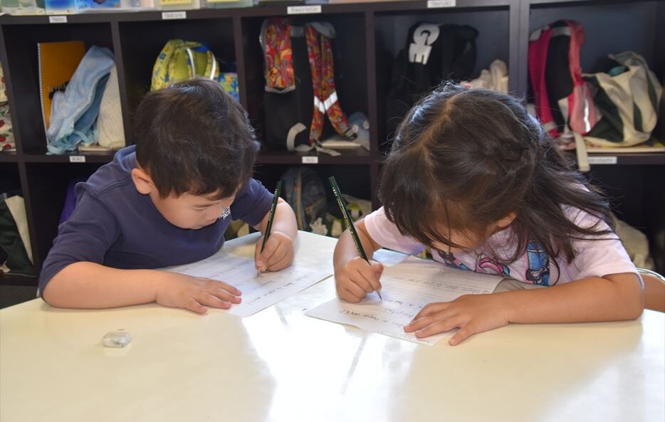 ヒルトップインターナショナルスクールで書き物をしている2人の子ども