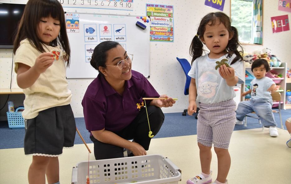 ヒルトップインターナショナルスクールで先生と一緒に釣りゲームをする子どもたち